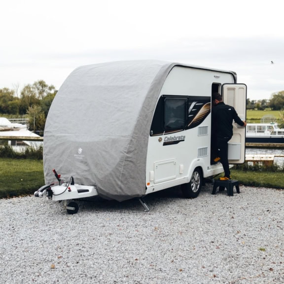Durable caravan cover shielding caravan from weather damage and UV rays, ideal for outdoor storage and preventing dirt and scratches.