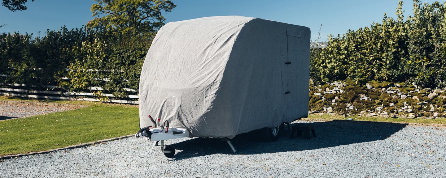 Durable grey caravan cover fitted securely, protecting against weather elements. Made from high-quality material, ideal for safeguarding your caravan when not in use or during transport.