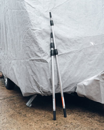 A picture of two extendable poles for fitting a caravan cover.