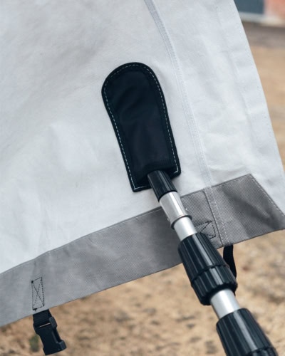 A picture of the extendable pole being placed on the inside pole pocket to aid fitting of a caravan cover.