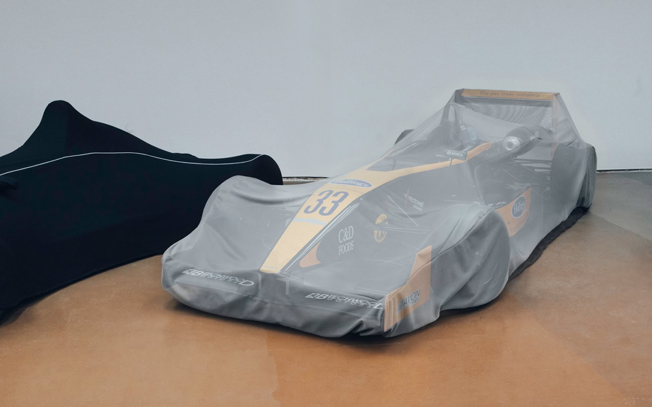 A high-quality protective cover designed specifically for race cars, ensuring optimal safety and dust protection during storage or transport.