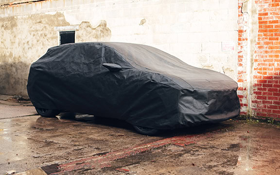 Durable outdoor car cover protecting vehicle from UK weather elements, including rain, snow, and UV rays, ensuring your car stays clean and dry in all seasons.