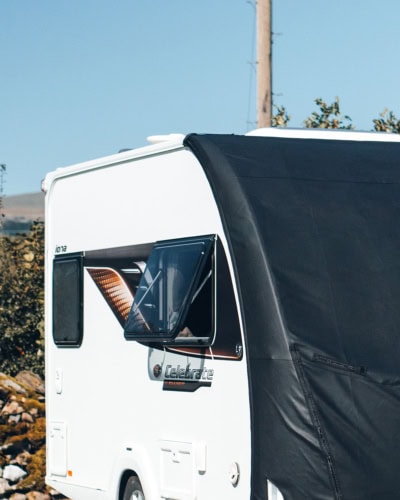 Durable black caravan cover for outdoor use, designed to fit Tow Pro Infinity caravans, shielding from weather elements and UV damage.