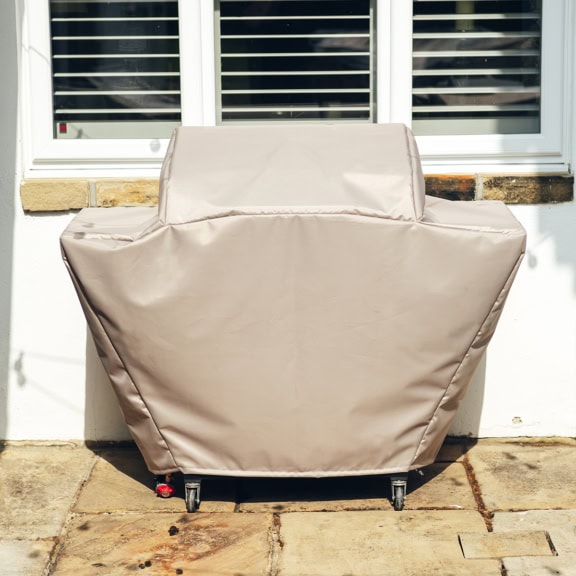Wide-fit BBQ cover shielding a barbecue grill from sun, rain, and dirt, ensuring durability and long-lasting protection for your outdoor cooking equipment.