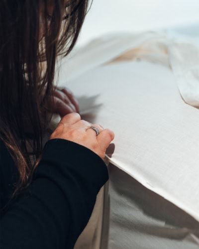 A picture close up of a designer working on a cloth pattern for a car cover.