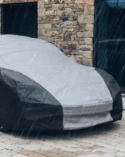 A picture of an Outdoor Plus cover on a car in the rain.