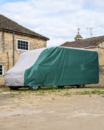A motorhome with a bespoke fit outdoor cover in green and grey,