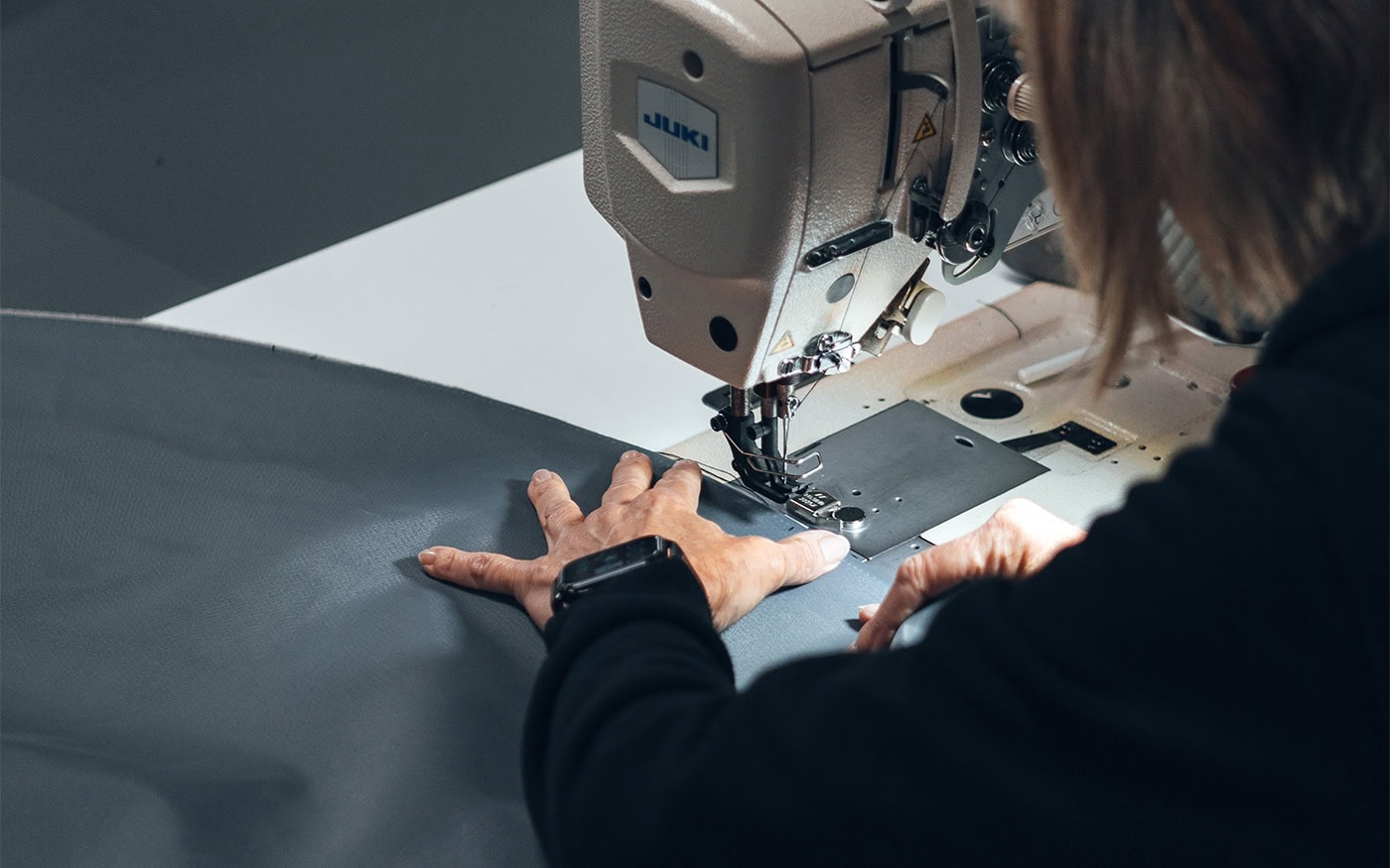 An image of our team in our UK factory, sewing together material to create a product.
