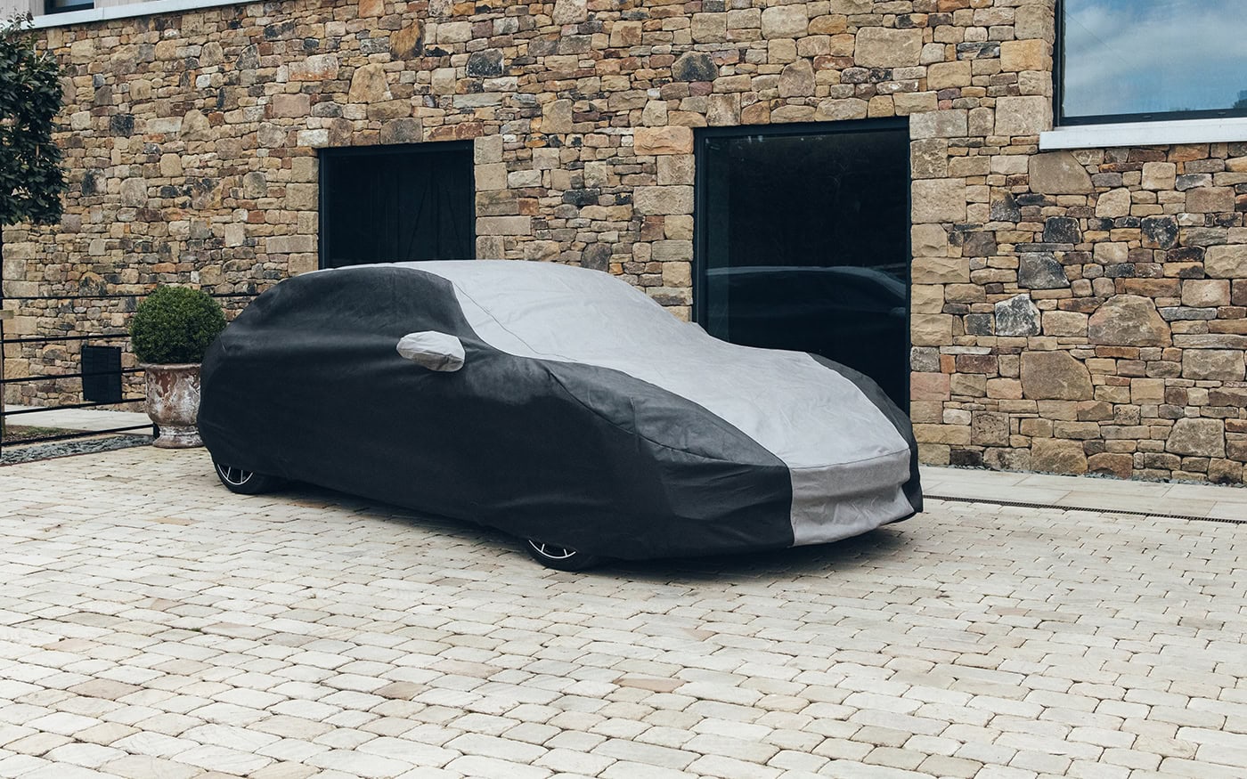 A picture of a Porsche outside a house with an Outdoor Plus cover on.