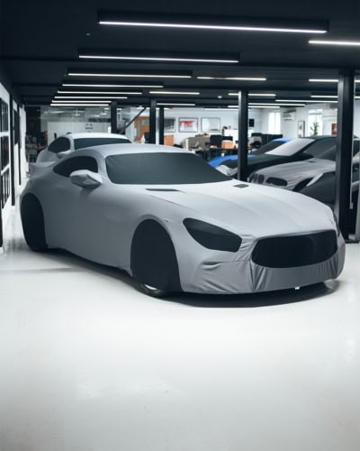 1. Premium car cover protecting luxury sports car in showroom, custom fit, durable material, high-quality vehicle storage solution.