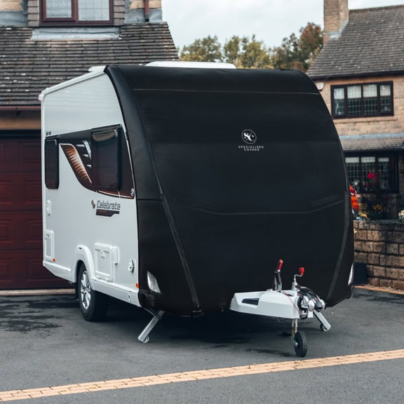 Black caravan cover with reinforced fabric, tailored fit, and UV resistance for Tow Pro Infinity Elite trailers, ensuring maximum protection from weather elements.
