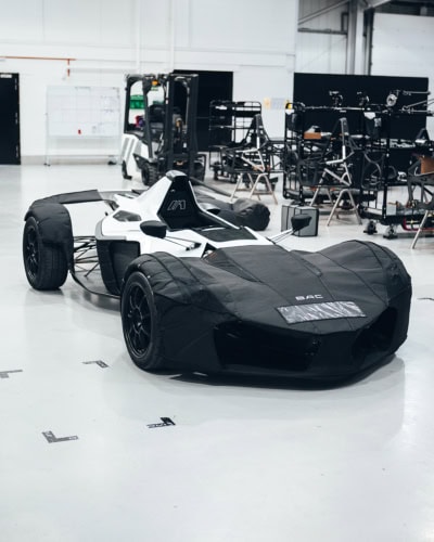 A custom car cover for high-performance race cars, providing protection in professional garages. Made to fit precisely, safeguarding the vehicle’s exterior from dust, scratches, and environmental damage. An essential accessory for race teams.