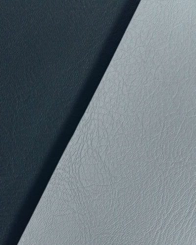 Close-up of high-quality black and grey leather fabric textures, showcasing durability and craftsmanship for bespoke covers and furniture projects.