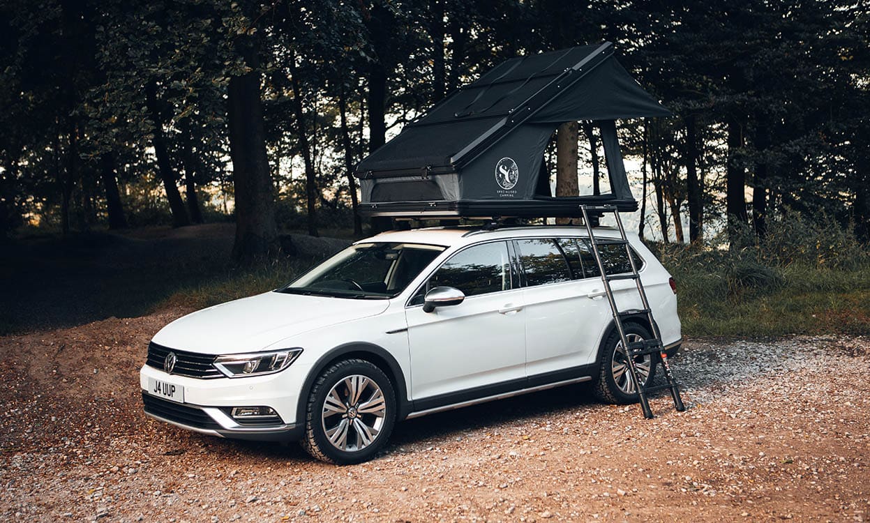 A white Volkswagen station wagon equipped with a custom-fit outdoor camping roof tent and cover, ideal for travel, outdoor excursions, and vehicle protection during adventures.