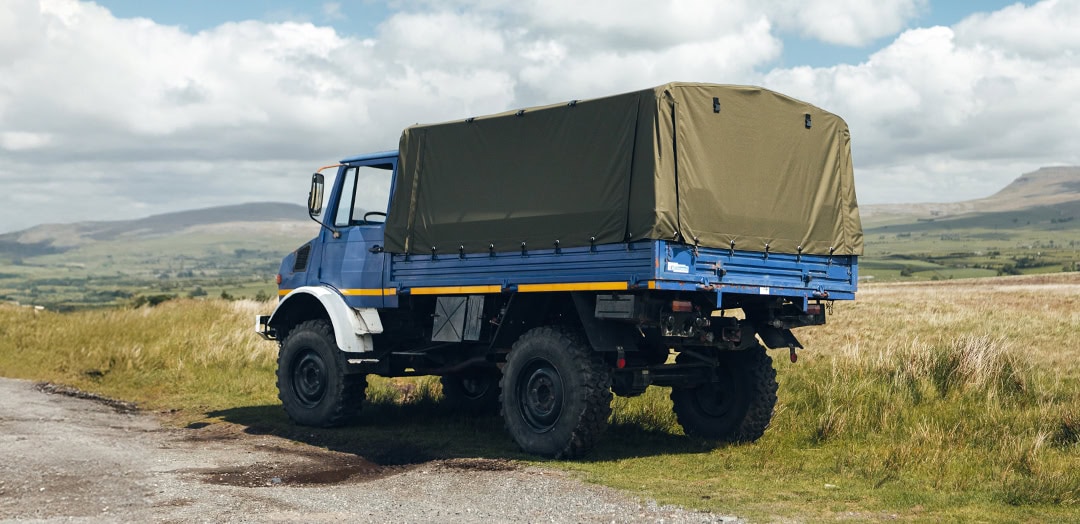Durable, custom-made Unimog cover for Atkinson Vos trucks, designed for maximum protection and weather resistance against outdoor elements in rugged terrains.