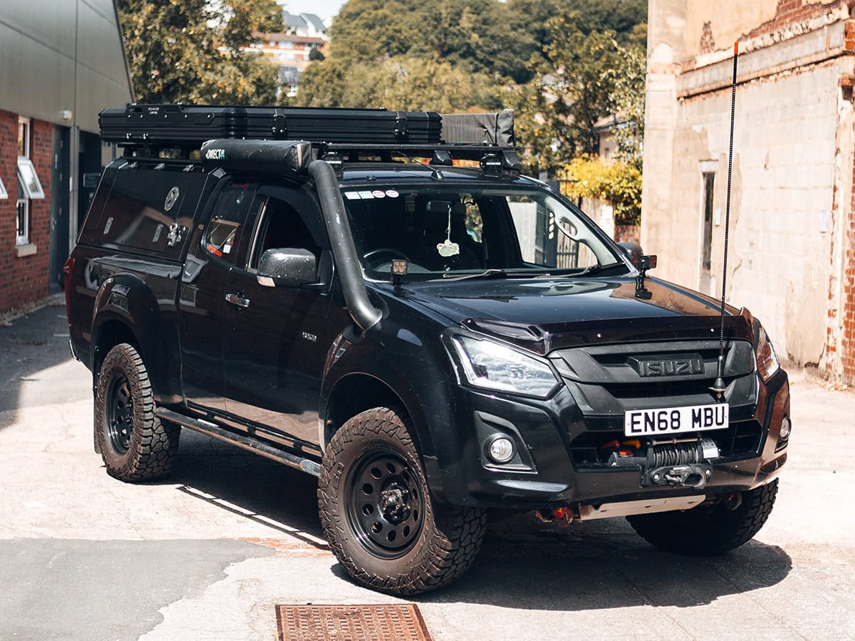 Versatile black off-road vehicle fitted with roof tent, equipped with specialised covers for enhanced durability and protection during outdoor camping adventures.