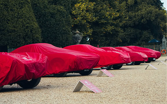 Custom vehicle covers protecting multiple cars parked on a gravel surface in an outdoor setting, showcasing high-quality, durable car covers by Specialised Covers.