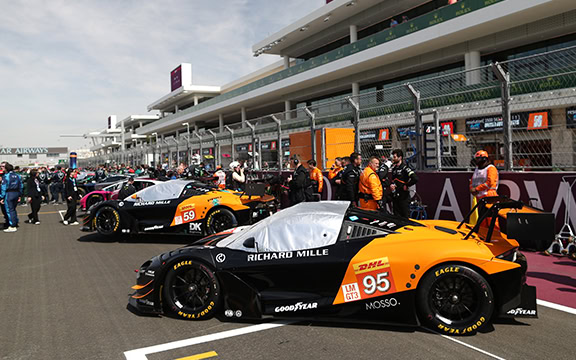 High-performance racing car covers at a motor racing event, designed to protect race cars on the grid from dust, weather, and damage, with specialised materials for maximum durability and easy fitting.