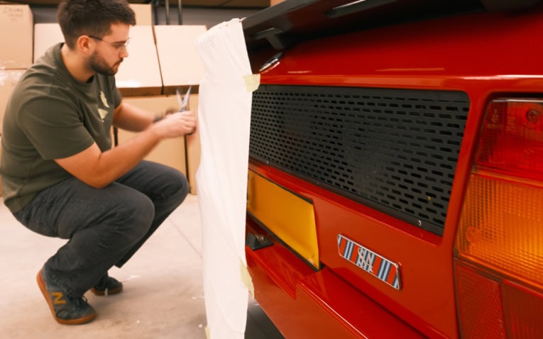 High-quality custom car cover being fitted on vintage red sports car, showcasing durable, weatherproof outdoor protection for Classic and Sports Car Cover by Specialised Covers.