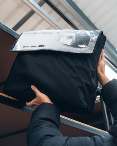 Durable black vehicle cover in packaging for outdoor protection, ideal for cars, vans, and RVs, with customisable options available from Specialised Covers.