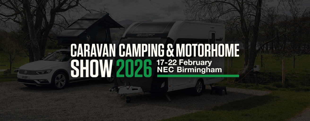 A caravan and motorhome parked outdoors with a cover, showcasing outdoor camping gear at the 2026 Caravan & Motorhome Show in Birmingham.