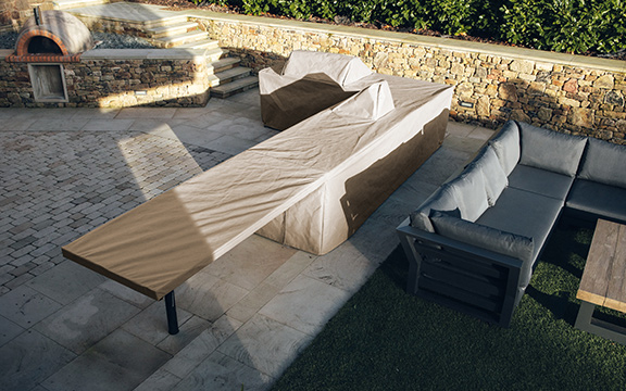 Durable custom outdoor furniture covers protecting tables and sofas from weather elements, ensuring longevity and maintaining appearance.