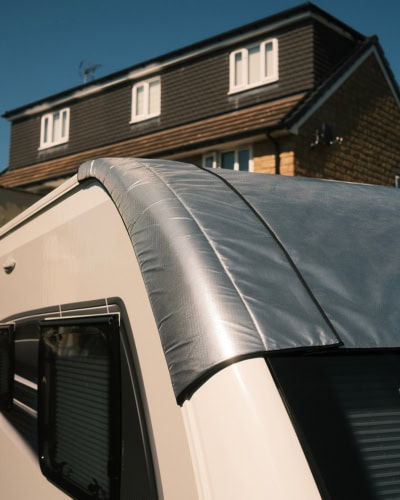 Close-up of a durable, weather-resistant specialised cover fitted over a caravan window, providing protection and privacy.