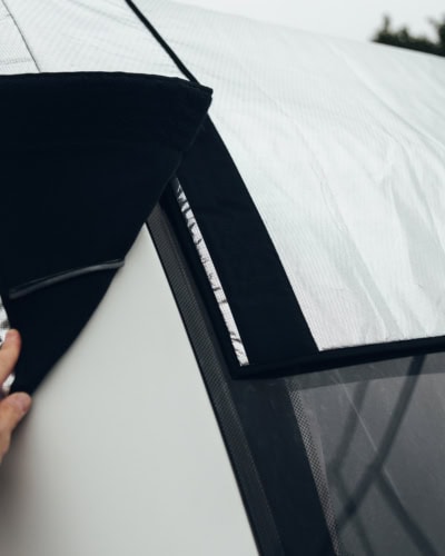 Close-up of a panoramic window cover with black and white fabric, showing the material and stitching details.