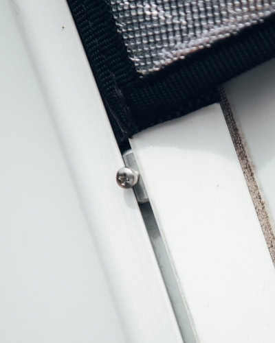Close-up of a specialised window cover with reflective material and secure fastening, showcasing high-quality protective covers from Specialised Covers.