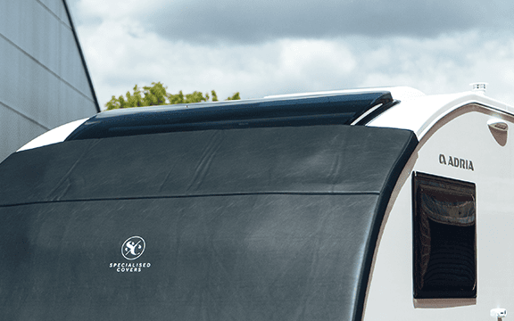 High-quality black towing cover for Adria caravans by Specialised Covers, providing durable protection against weather and road debris.